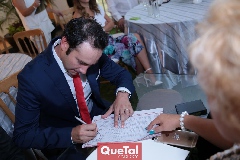 Ernesto Araiza firmando.