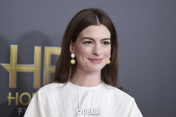 Anne Hathaway luce un jumpsuit de pantalones blanco con lentejuelas y sandalias de plataforma